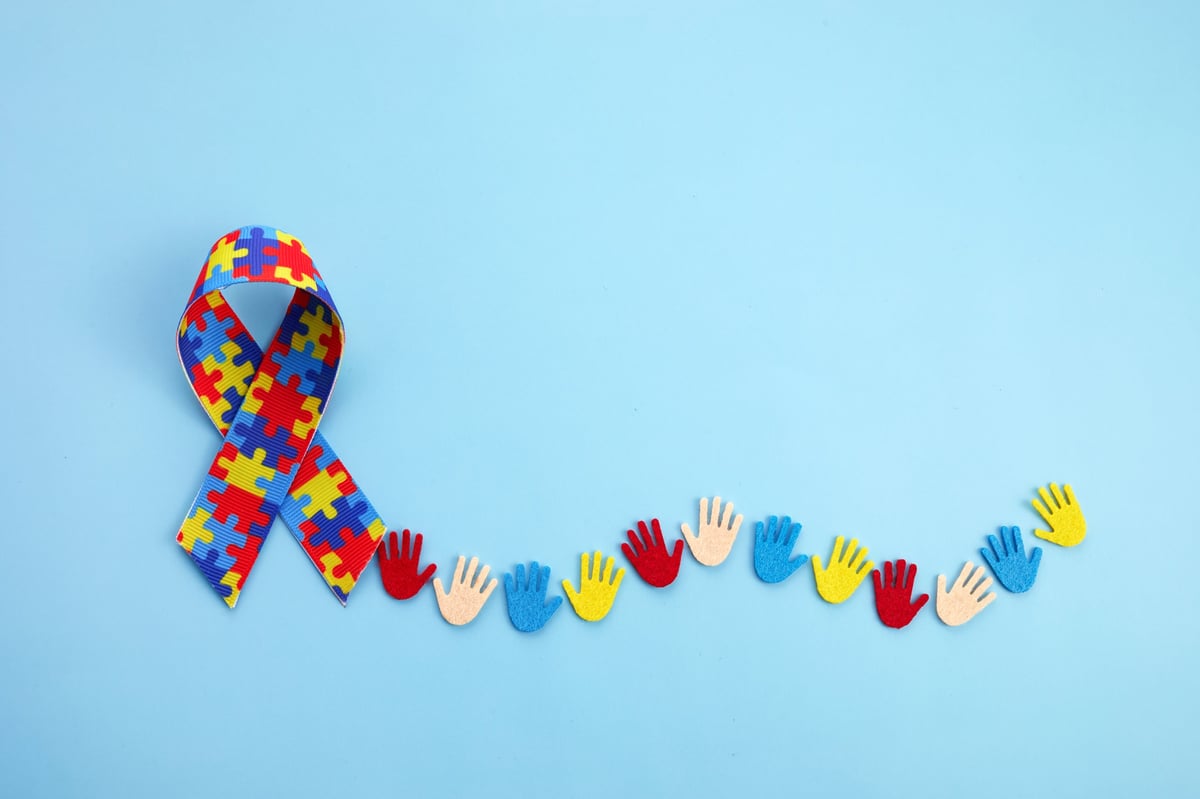 Autism awareness concept with colorful hands on blue background