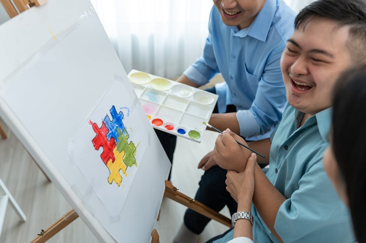 Asian happy family draw picture with young son in living room at home