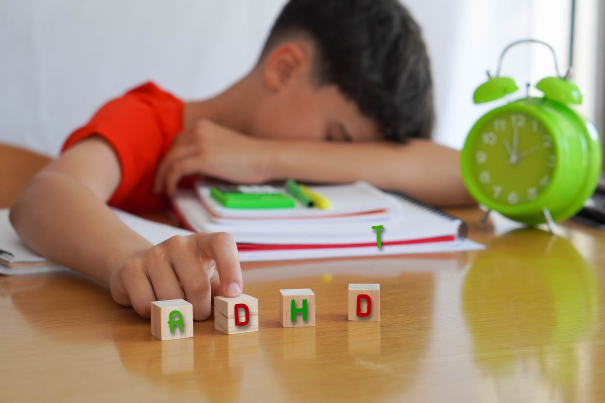 Child surrounded by books and notebooks frustrated, with ADHD representing difficulties in school life