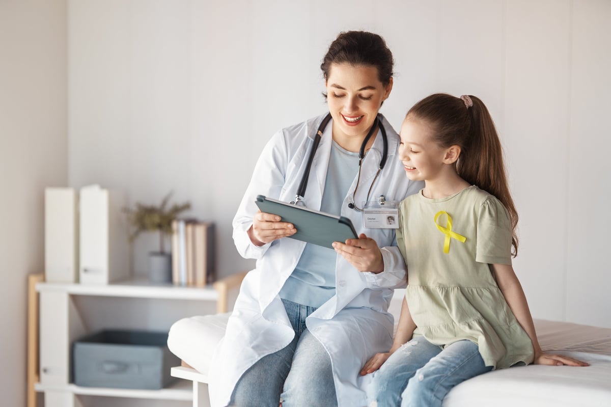 World Childhood cancer Day. Girl patient listening to a doctor in medical office.