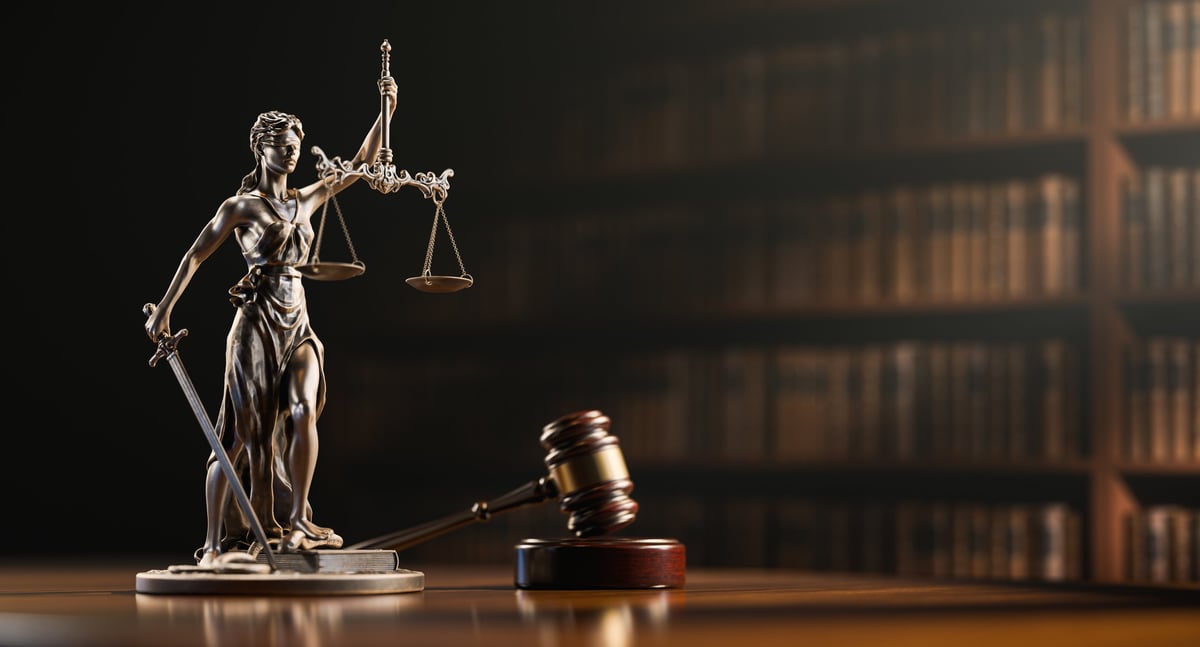 Legal Concept: Themis is the goddess of justice and the judge's gavel hammer as a symbol of law and order on the background of books