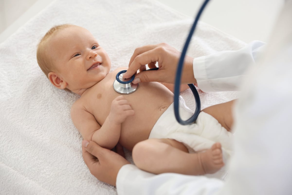 Pediatrician examining baby with stethoscope in hospital