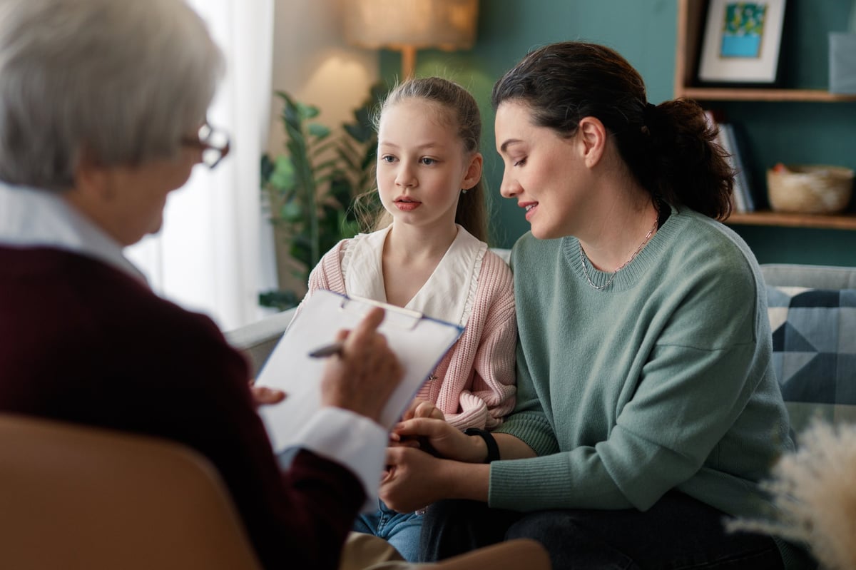 Emotional and supportive family therapy session featuring a mother and daughter with a therapist