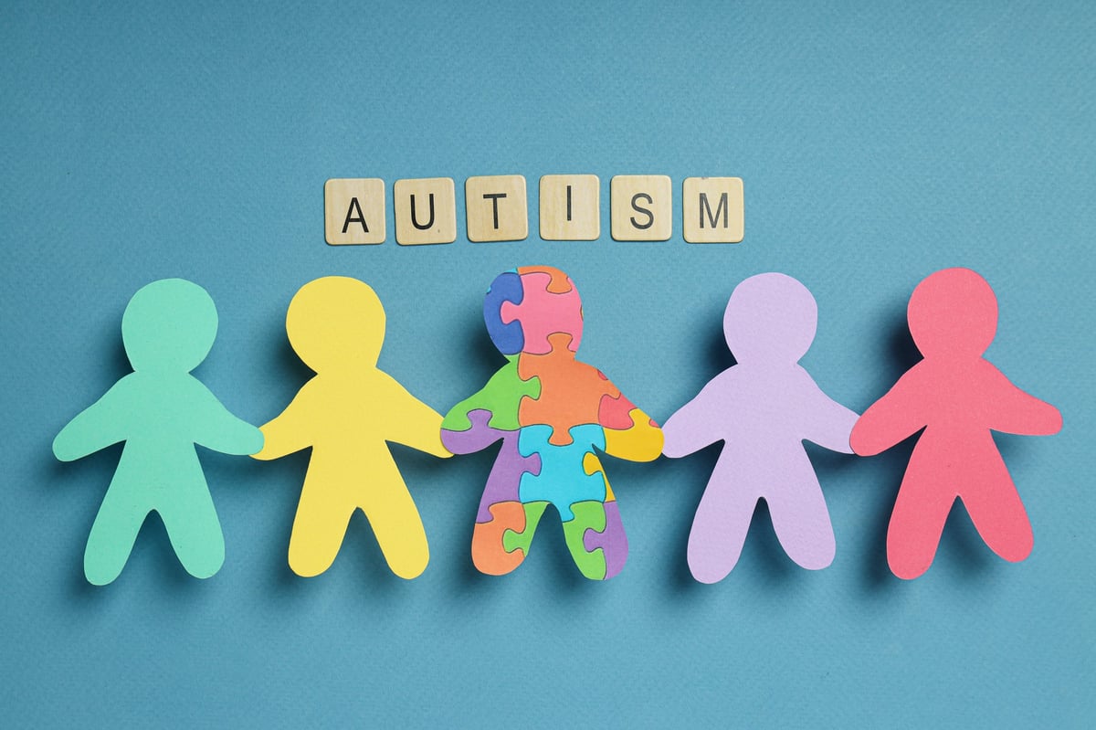 Paper figures of people on a light background representing world autism day